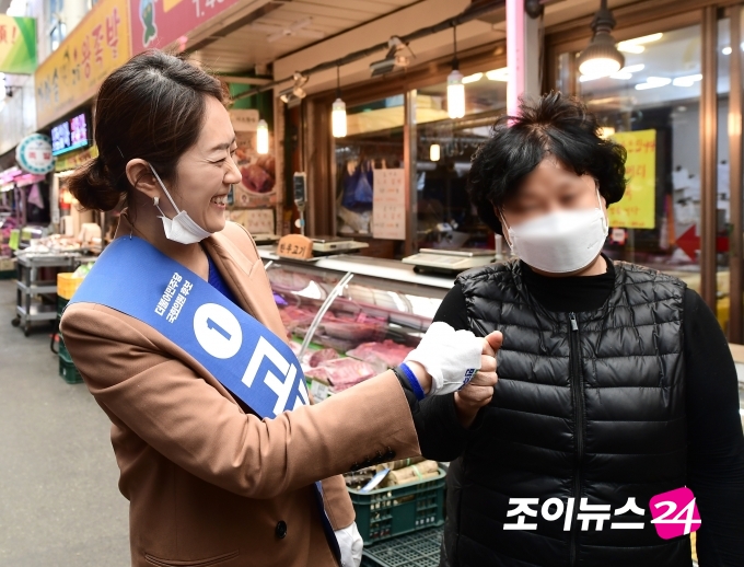 고민정 더불어민주당 후보가 시장 상인과 주먹을 부딪히고 있다. [사진=정소희기자]